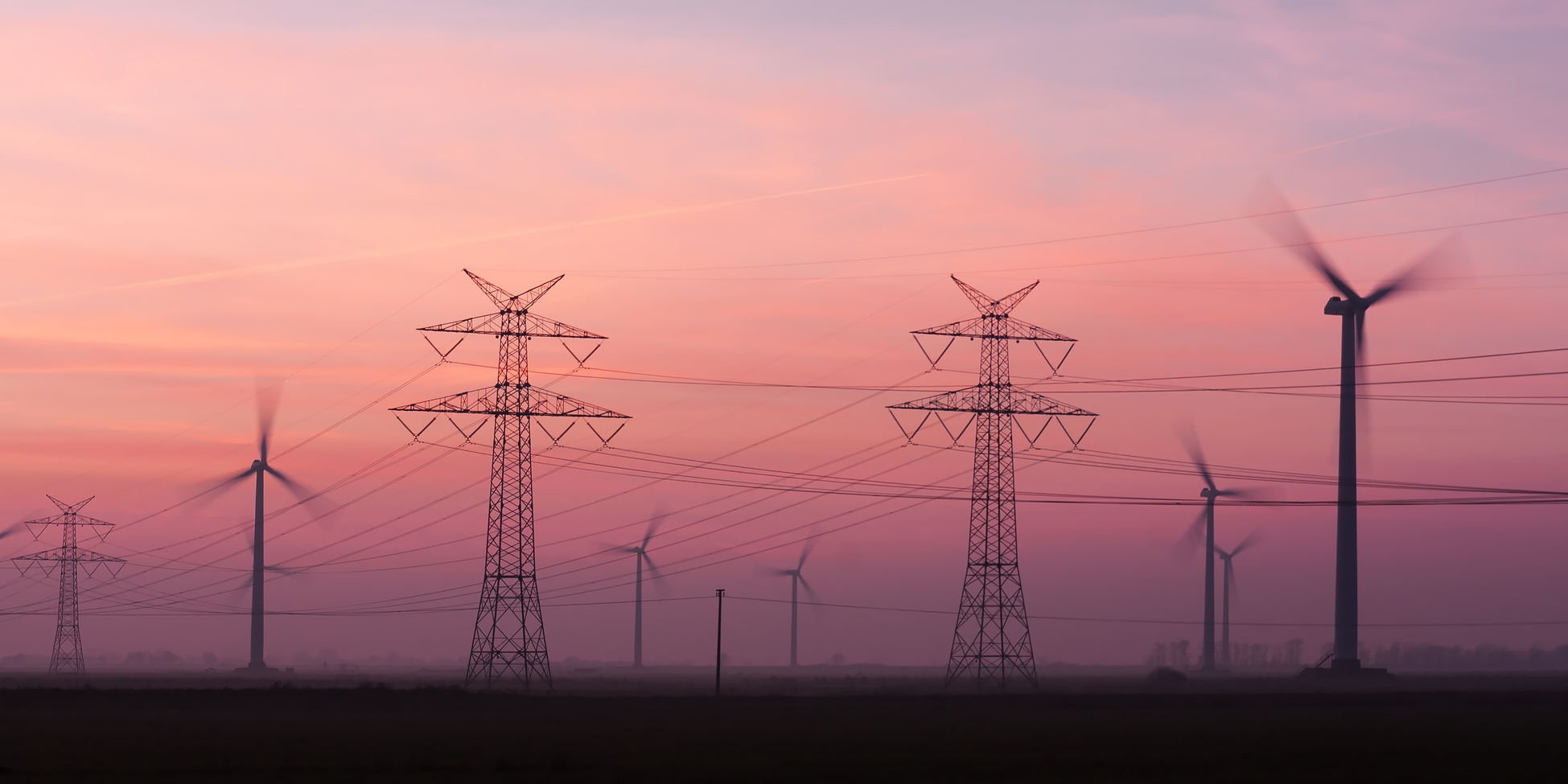 ASTROSE® zuverlässig wirksam unabhängig | Strommasten von Hochspannungsleitungen und Windräder in der Abenddämmerung in Schleswig-Holstein. 